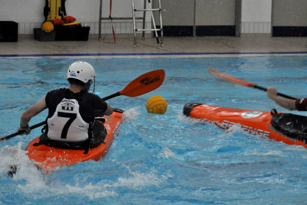 Canoe polo players chase the ball