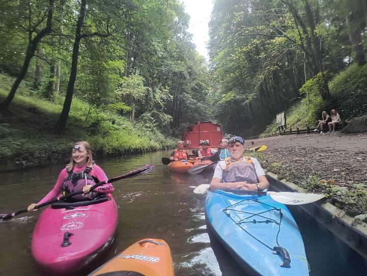 A group of people in kayaks on a river

Description automatically generated