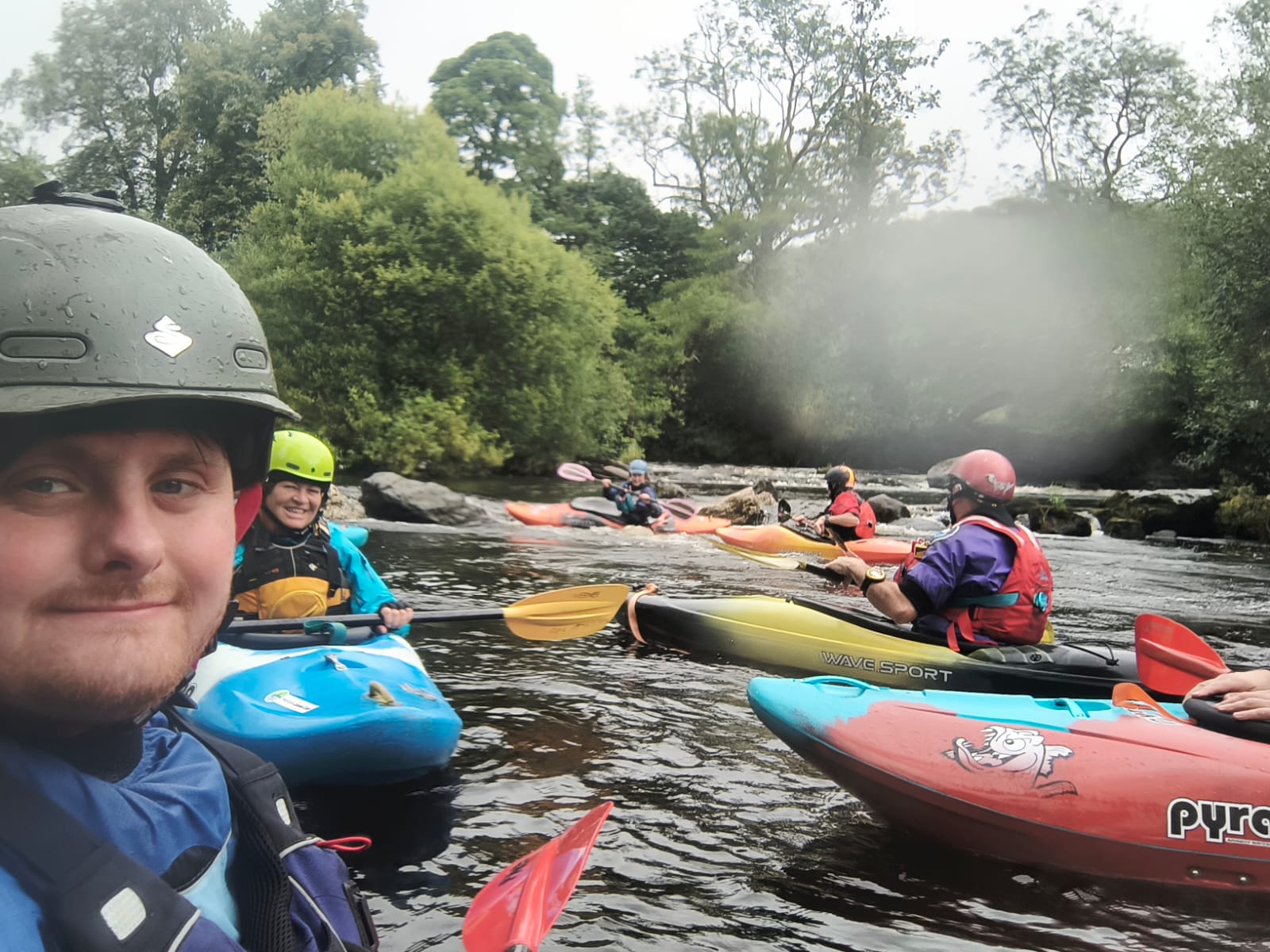 A group of people in kayaks on a river

Description automatically generated