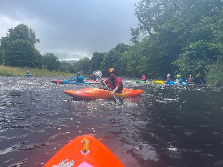 A group of people in kayaks on a river

Description automatically generated