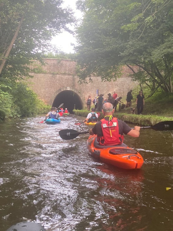 A group of people kayaking in a river

Description automatically generated