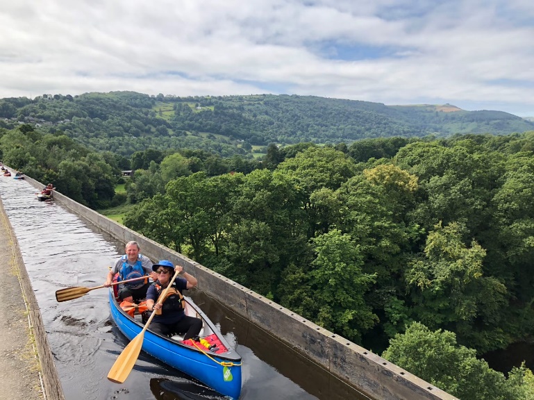 People in a canoe on a river

Description automatically generated