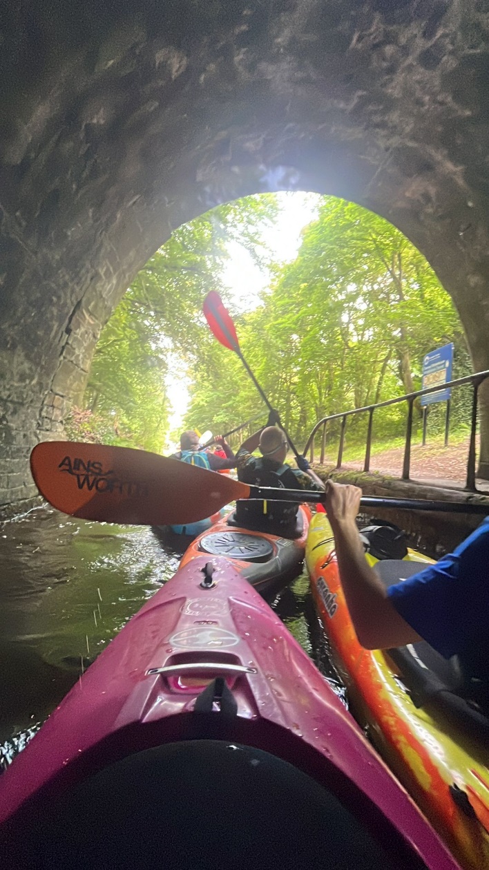 People kayaking under a bridge

Description automatically generated